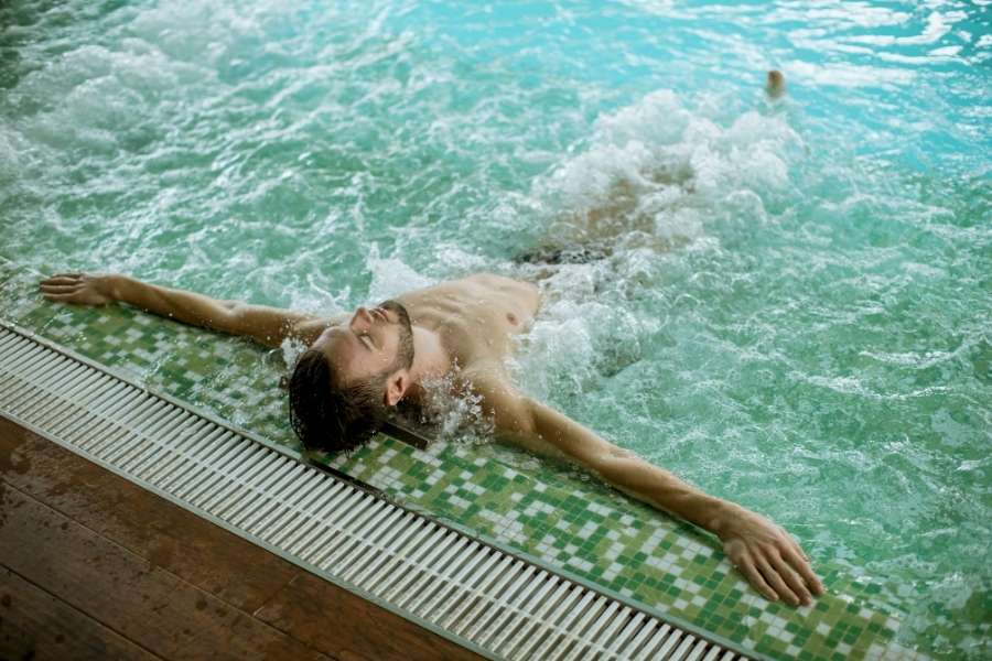 Un homme profite d'un bain à bulles relaxant dans une piscine de thalassothérapie.